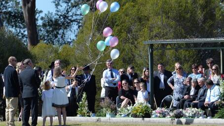 Ten balloons - pink, white, green and blue - are released at the conclusion of the Hunt family funeral at the Lockhart Cemetery on Tuesday. Picture: Michael Frogley