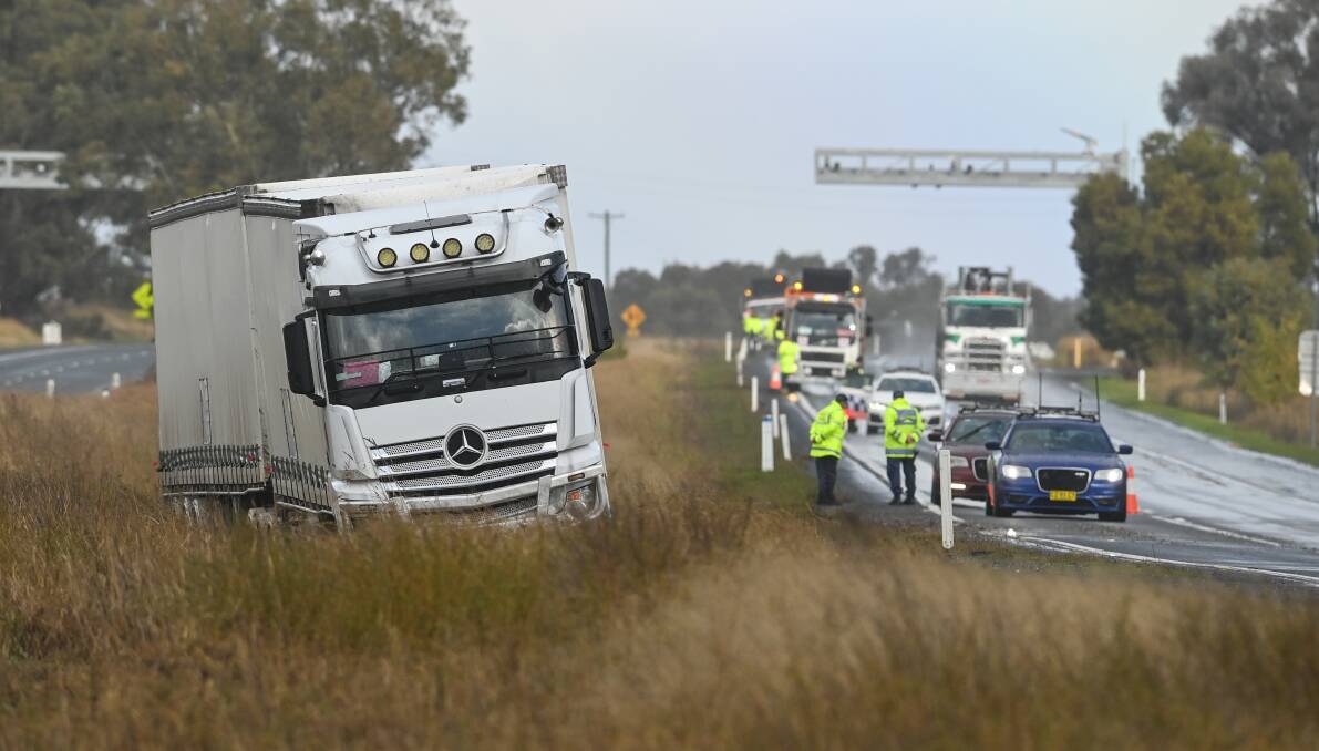 OFFLINE: The white Mercedes Benz truck became stuck on the side of the Hume Highway at Table Top yesterday, in an almost identical spot to an ambulance that slid and rolled on Saturday. Picture: Mark Jesser