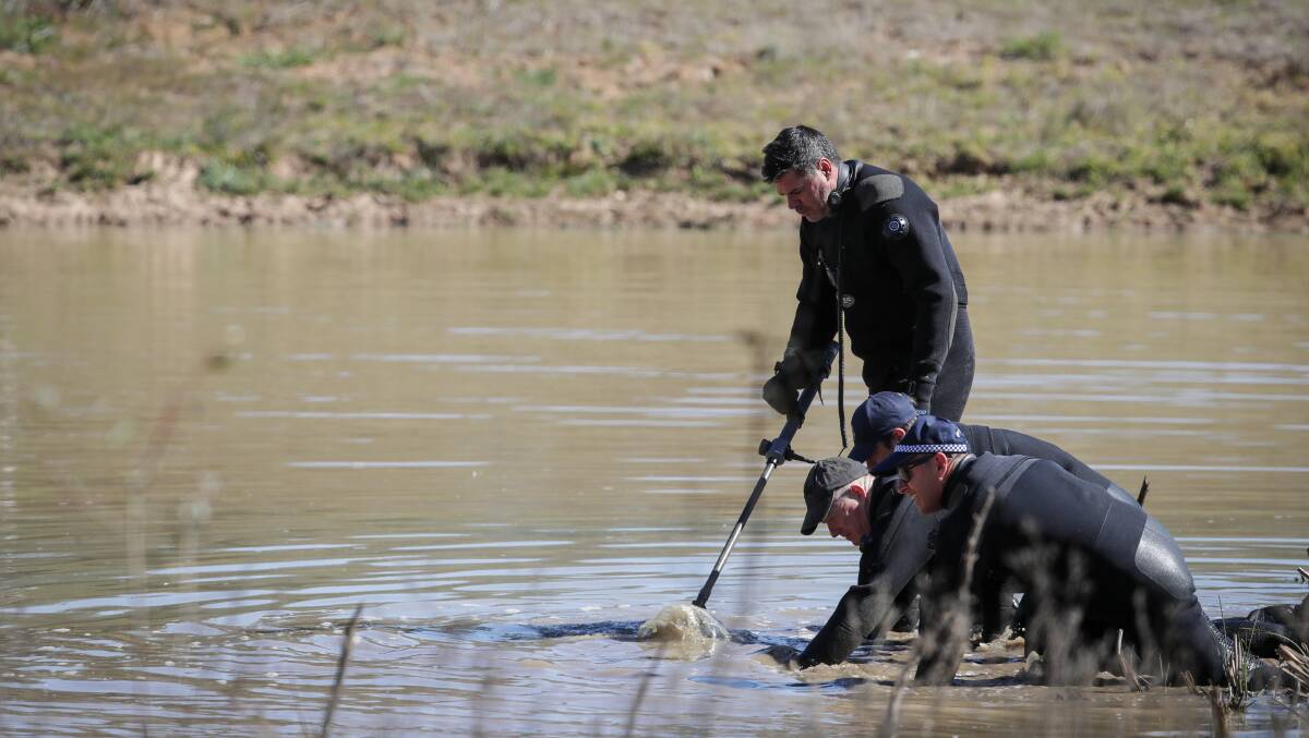 SEARCH: Police examine a dam for weapons. 
