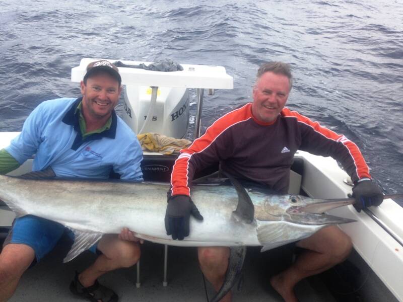 BIG CATCH: Marty Asmus and Craig Harris hold a black marlin off Bermagui, NSW.