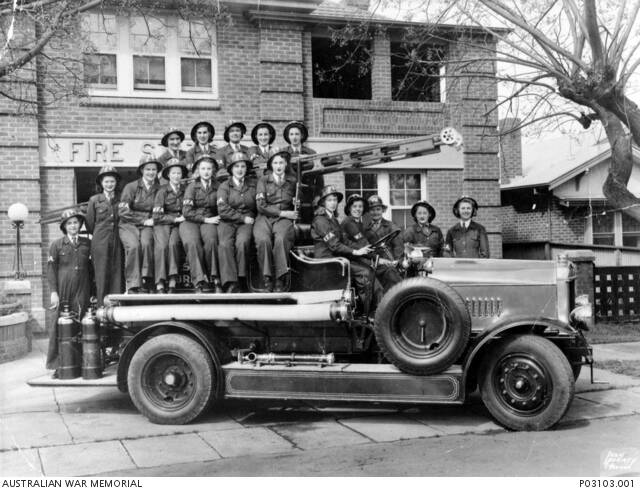 SERVICE: Members of Wagga Wagga Women's Australian National Service (WANS) Fire Brigade Auxiliary Division on a fire engine in front of the fire station about 1942. Photo: Australian War Memorial.