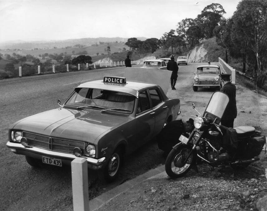 CLASSIC RIDES: Police cars and a motor bike in the late 1960s working on what is thought to be a stretch of the Sturt Highway east of Wagga. The fleet of official vehicles comprised a range of makes including the iconic Holden.