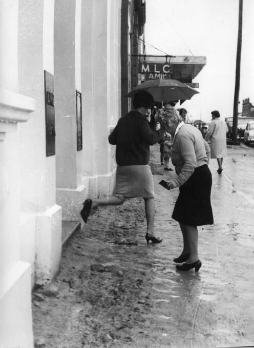 WET UNDER FOOT: Getting the banking done can be a dangerous business (outside the ANZ bank on the corner of Fitzmaurice and Johnston Street). Photo: Tom Lennon Collection CSURA RW1574.844