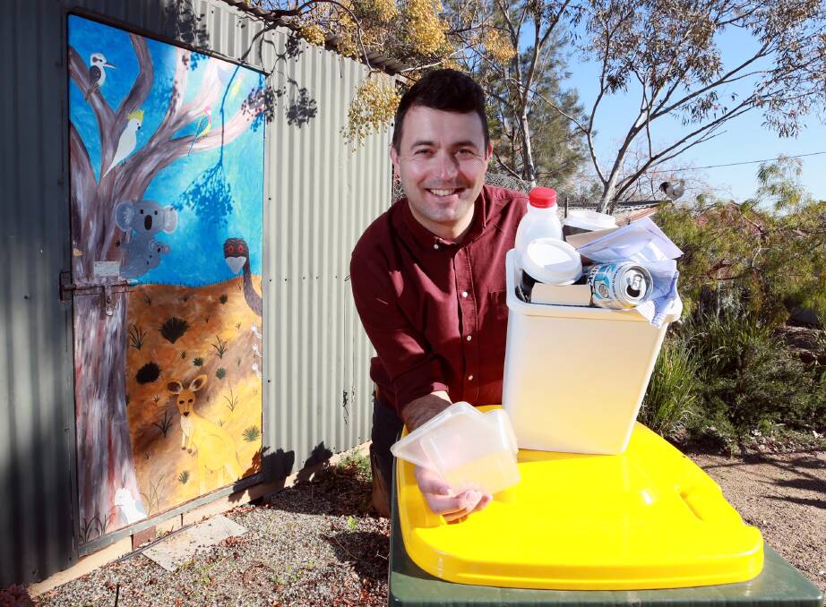 ECO-FRIENDLY: Benjamin Holt demonstrates good waste disposal habits at Erin Earth. Picture: Les Smith