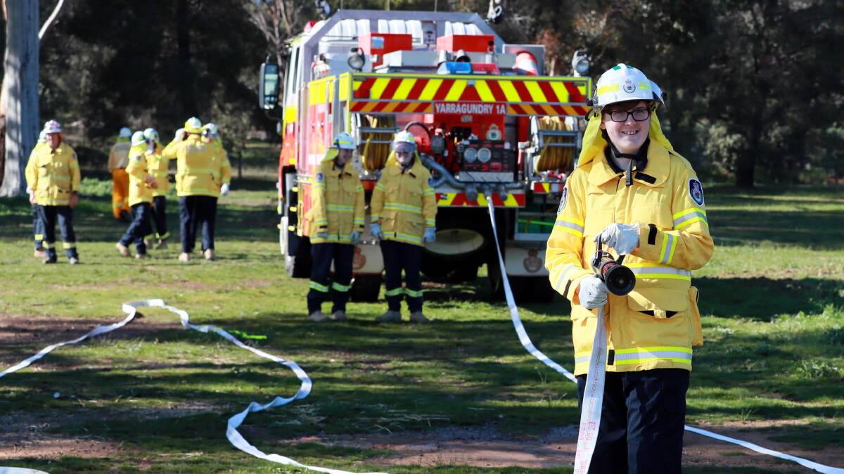 HANDS ON: Harry White, 14, mans the fire hose as part of the emergency simulations at the Yarragundry RFS shed. Picture: Les Smith
