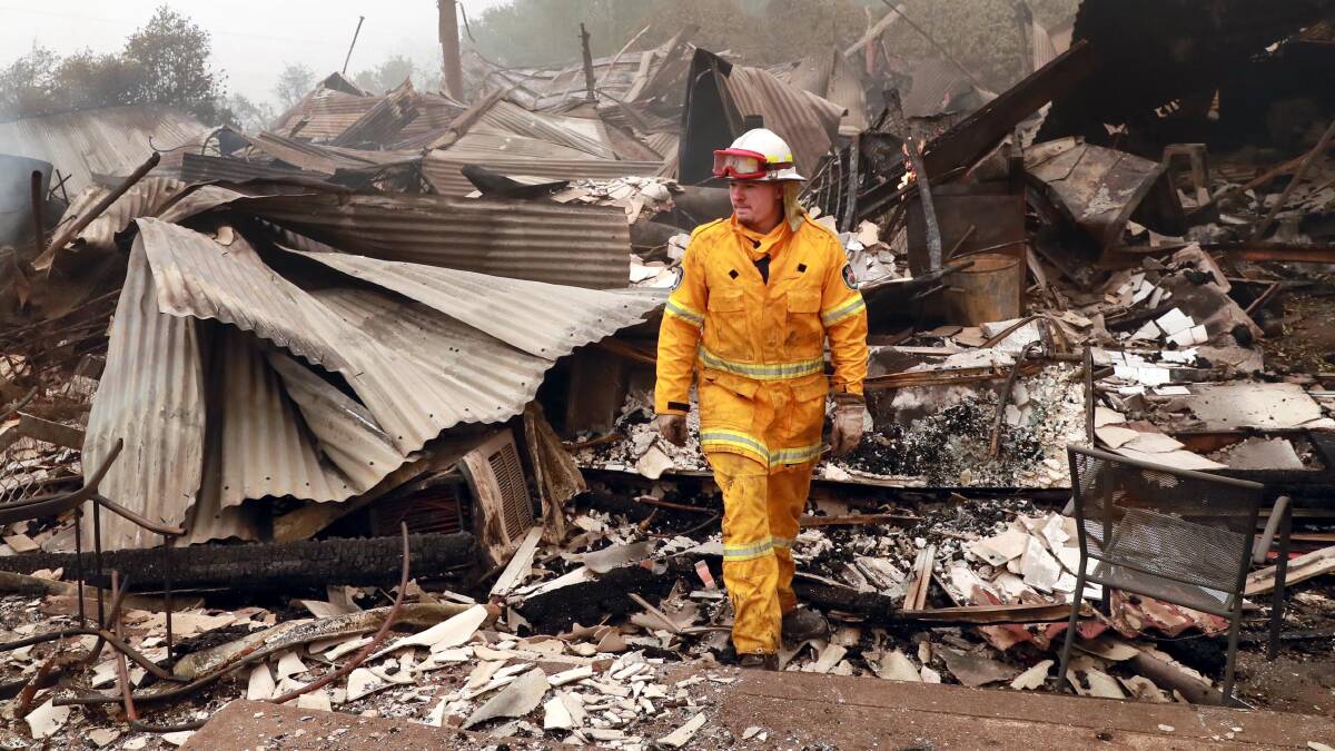 DEVASTATION: Dareton Fire Brigade's Chris Gibson assesses the damage from the Dunns Road bushfire at the Old Batlow Hospital. Picture: Les Smith