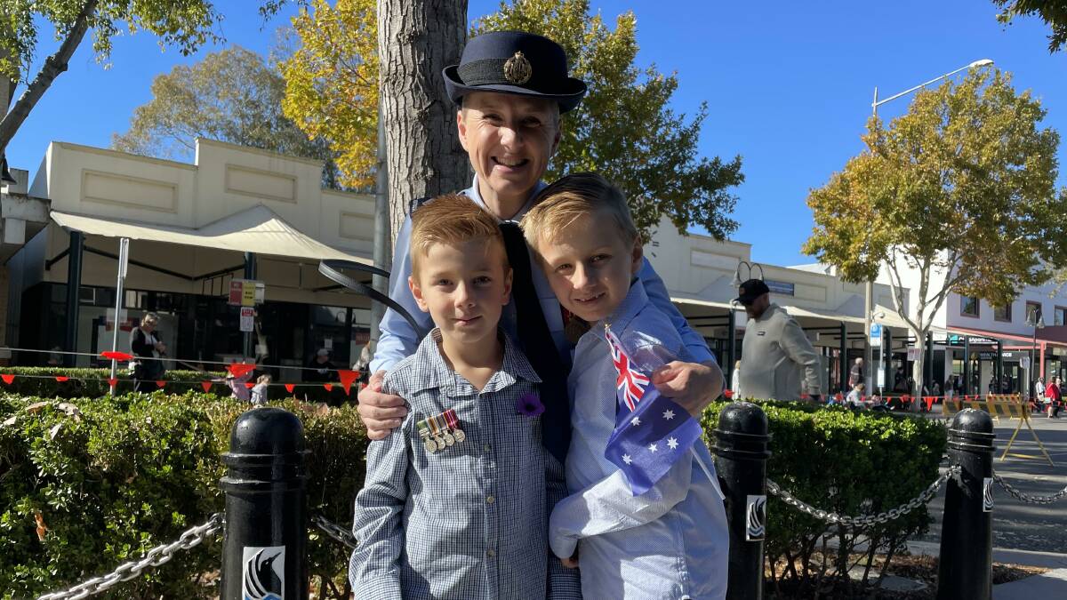 IN THE FAMILY: Ellen Potter shares the Anzac spirit with her two boys Caleb, 6, and Levi, 9, as they wait for their dad to march past down Baylis Street. Picture: Jessica McLaughlin