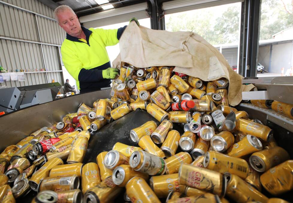 East Wagga Return and Earn floor hand Trevor Knight unloads another lot of cans into the hopper.