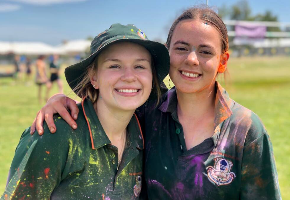 COLOURFUL: Holly Wilson and Anna Falepau get amongst the action of the colour run. Picture: Contributed