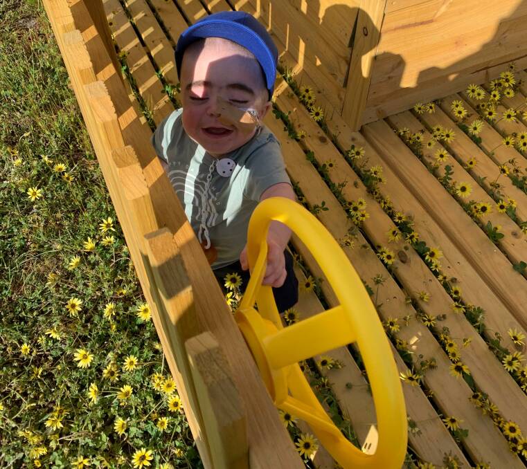 TAKE THE WHEEL: Henley Carey, 1, is enjoying playing in his own backyard after spending months in a Sydney hospital. Picture: Contributed