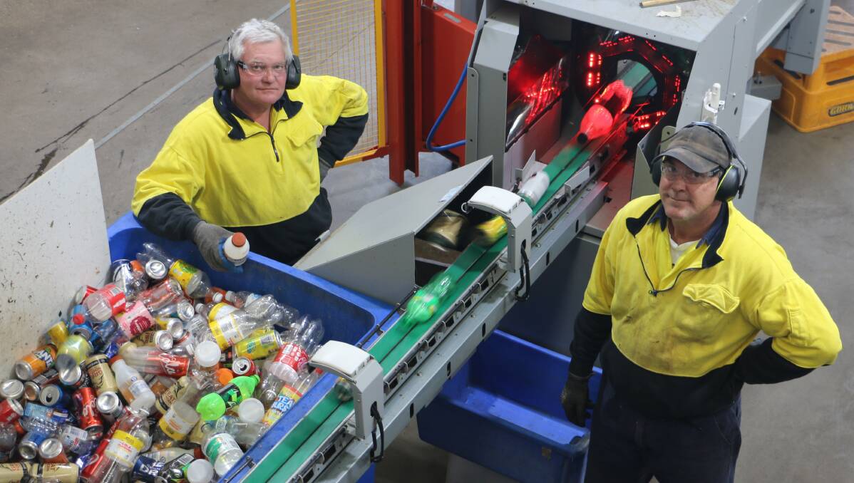 SUPPLY CHAIN: Wayne Barratt and Jim Kerin help sort empty cans and bottles at Wagga's Vinnies deposit centre. Picture: Jessica McLaughlin