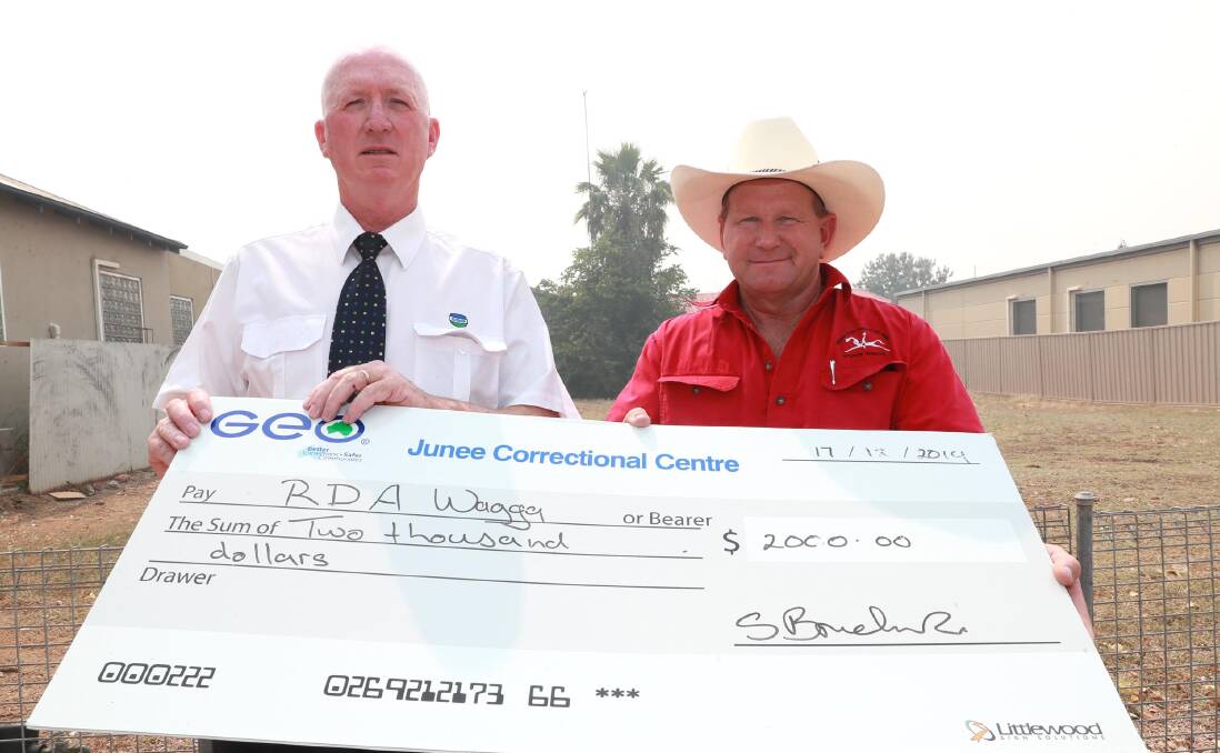 GRATEFUL: Trevor Coles of Junee Correctional Centre hands over the check to a thankful Darren Judd of Riding for the Disabled Association Wagga. Picture: Les Smith