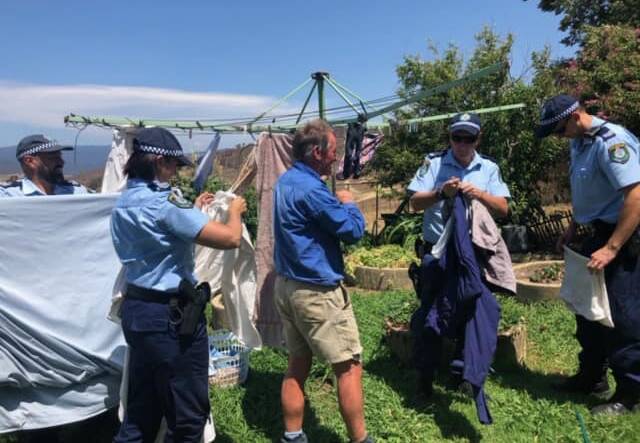 Officers help Robert take his washing off the line. Picture: Riverina Police District