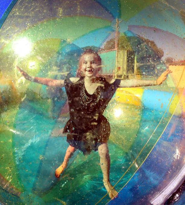 HAVING A BALL: 7-year-old McKenna Atkins rolls around in the inflatable ball at the Foodies Night Markets in February. Picture: Les Smith