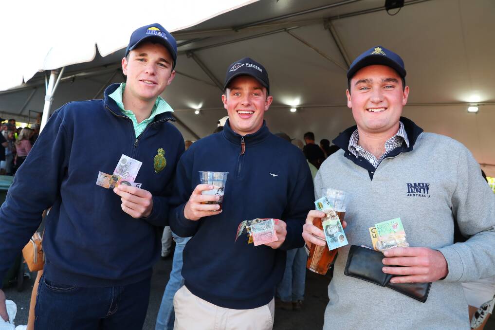CASHED UP: Bill Ryan, Sam Mackay and Benjamin Lovett get into the spirit of Two-up at The Farrer. Picture: Emma Hillier