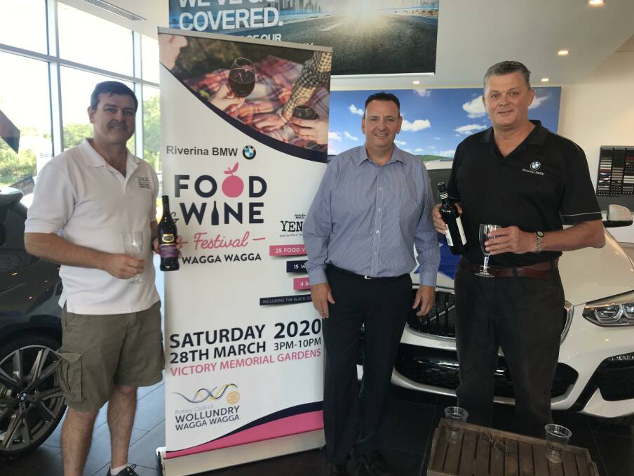 CHEERS: The Food and Wine Festival's Andrew Puckeridge celebrates their decision with the major sponsor, BMW's Stephen Hodgson and David Kelly.