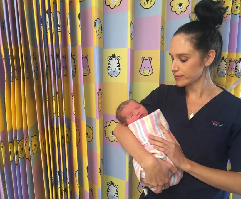 FIRST BREATH: Midwife Carly Fisher holds the first baby girl welcomed into the world at Wagga Base Hospital. Photo: Daisy Huntly.