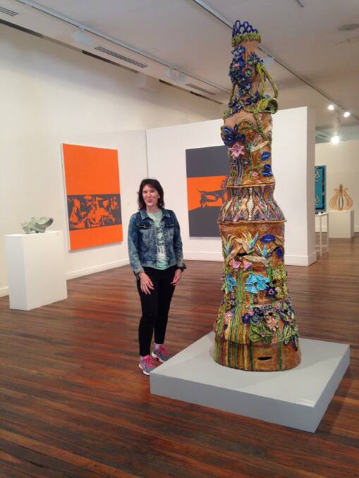 Amanda Bromfield stands with her 3 metre tall ceramic sculpture inspired by womens stories, titled Hey, Listen Up.