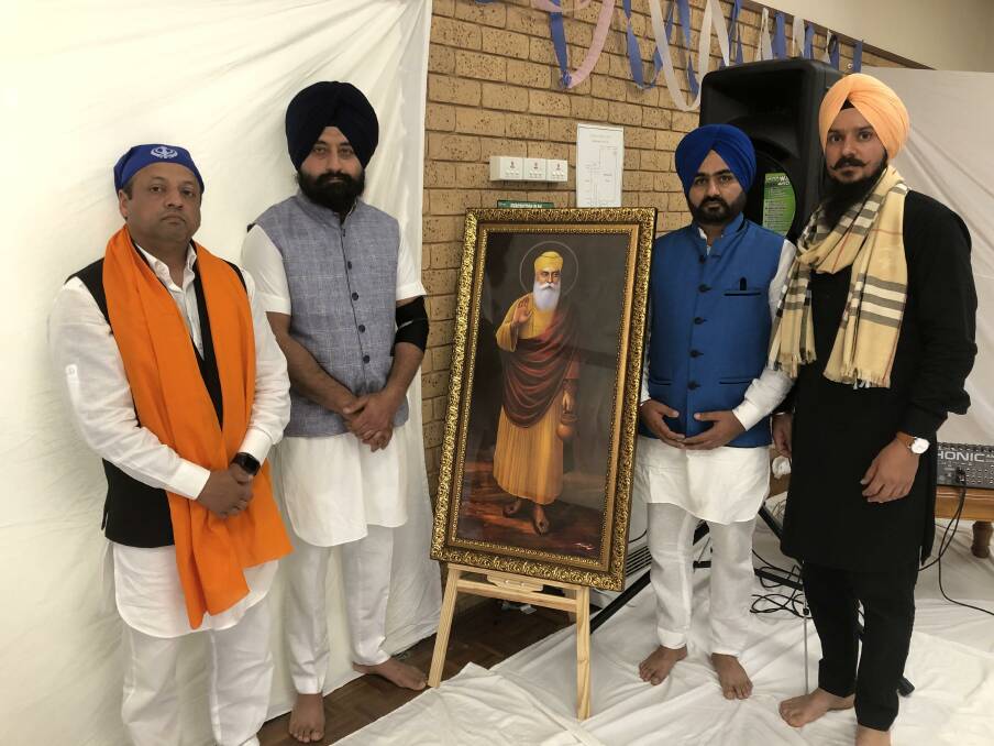 Amit Gupta, Aman Paricha, Sarvjeet Singh and Damandeep Uppal of the Wagga Indian Community with a portrait of Guru Nanak.