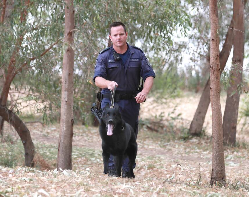 Senior Constable Karl Harris with Buster the general purpose police dog. Picture: Les Smith