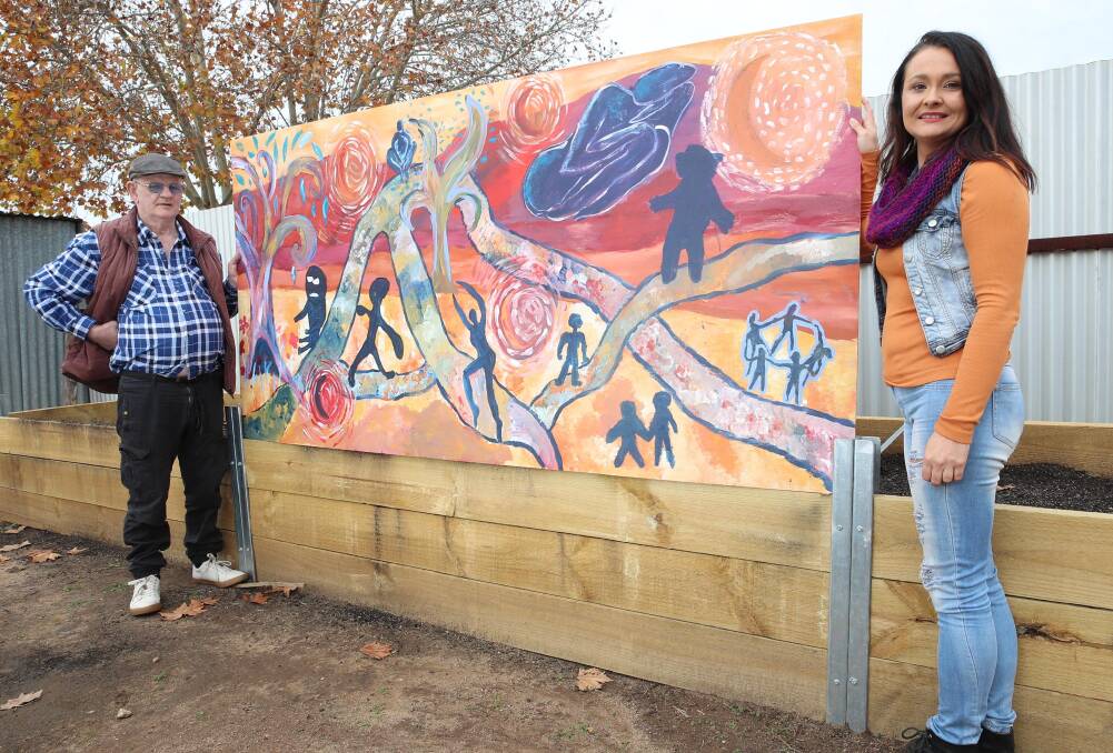 CREATIVE: Sunflower House art class participant Bill Budd and teacher Sheree Ridley show off their latest work, 'Journey', as a feature of the community gardens being built. Picture: Les Smith