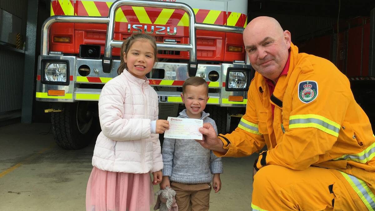 LITTLE HELPERS: Bebina Curtis' grandchildren, Mila and Nicholas Burrows, hand over the donation to Steve Howe. Picture: Contributed