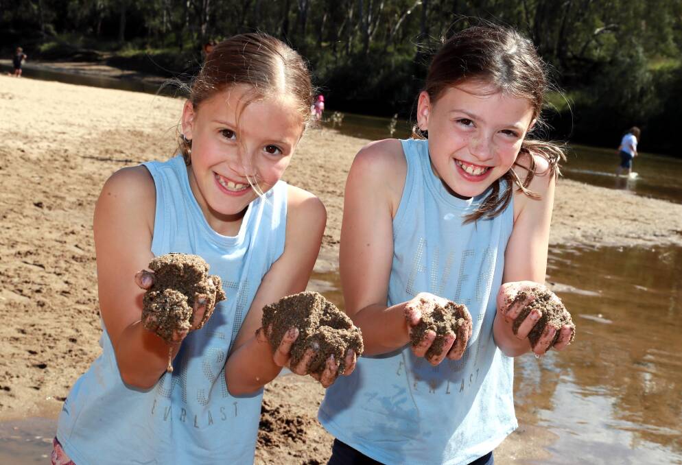 HANDS ON: 10-year-old twins Flo and Laine Griffiths get their hands dirty making sand castles at Wagga Beach. Picture: Les Smith
