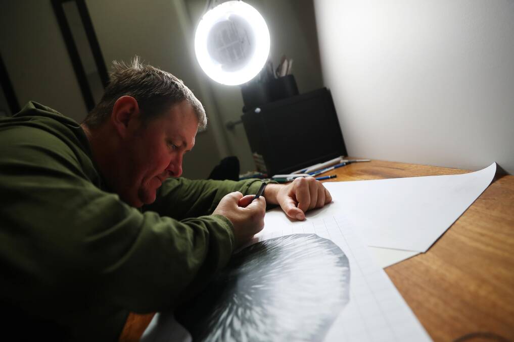 EYE FOR DETAIL: Stephen Williams works on a drawing of an echidna in his home art studio. Picture: Emma Hillier