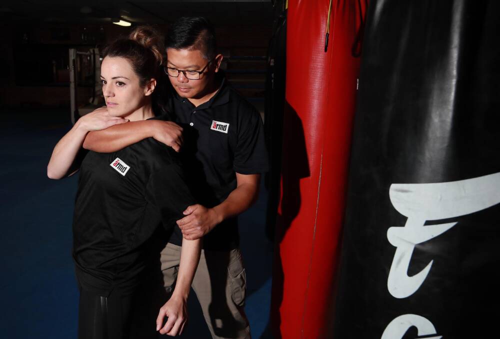 TAKE CHARGE: Caitlin Langley prepares to use her self defence skills to get out of David Bardos' grip in a simulation scenario. Picture: Les Smith
