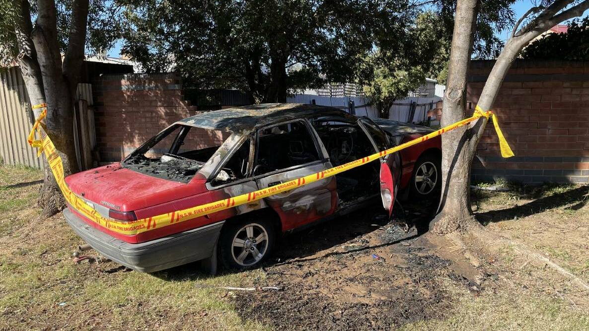 The remains of a car that was rammed into a backyard wall before being set alight in Anne Street in Tolland early on Saturday morning. Picture: Rex Martinich