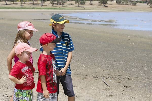 WHERE’S THE WATER? Lake Albert children (from left) Chloe Davey, 7, Charlie Davey, 3, Izac Davey, 5, and Ryan Nicholl, 10, look out across Lake Albert over the weekend as dead fish litter the area.  Picture: Glenn Henderson