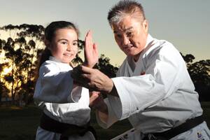 Singapore National Karate Coach Richard Ng gives instruction to his past student's daughter, Hana Sawal aged 8.