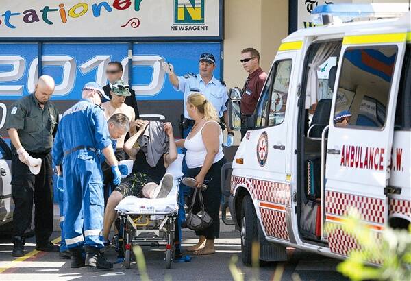 AFTER-SCHOOL STABBING: Paramedics, police and Sturt Mall security guards assist an 18-year-old man onto an ambulance stretcher after he was stabbed in the thigh in front of horrified school students.  Pictures: Glenn Henderson