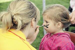 WHISKERS: Sally Mumford paints three-year-old Shylah White’s face during the Little Big Day Out event yesterday. Picture: Hayley Hillis