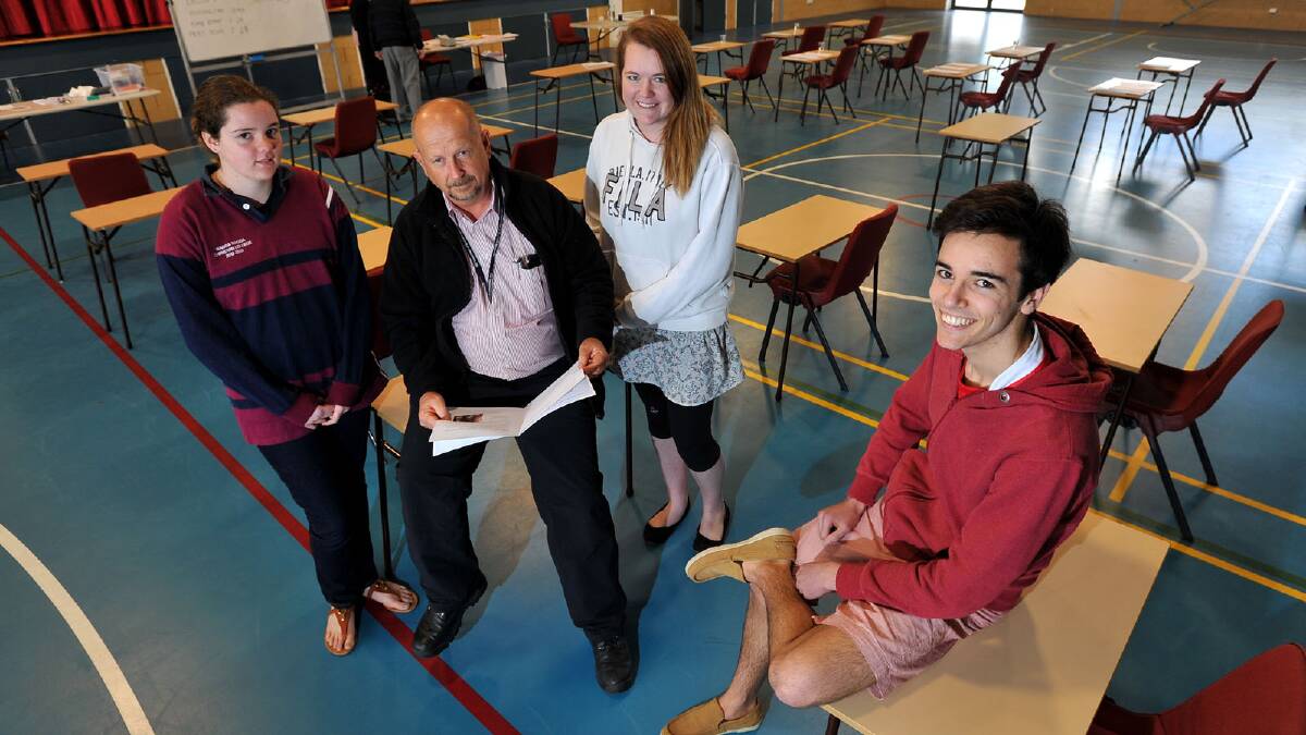 Wagga Christian College's (from left) Alesha Swan, 17, senior English co-ordinator Dave Hancock, Jessica Mees, 18, and Brayden Morris, 18, going over the paper after the exam. Picture: Addison Hamilton