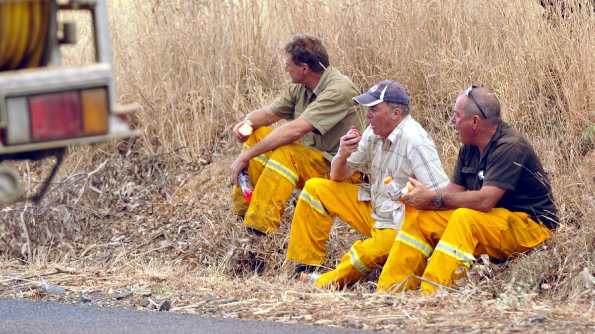 Rural Fire Service volunteers stop for a quick snack before returning to the front. Picture: Les Smith