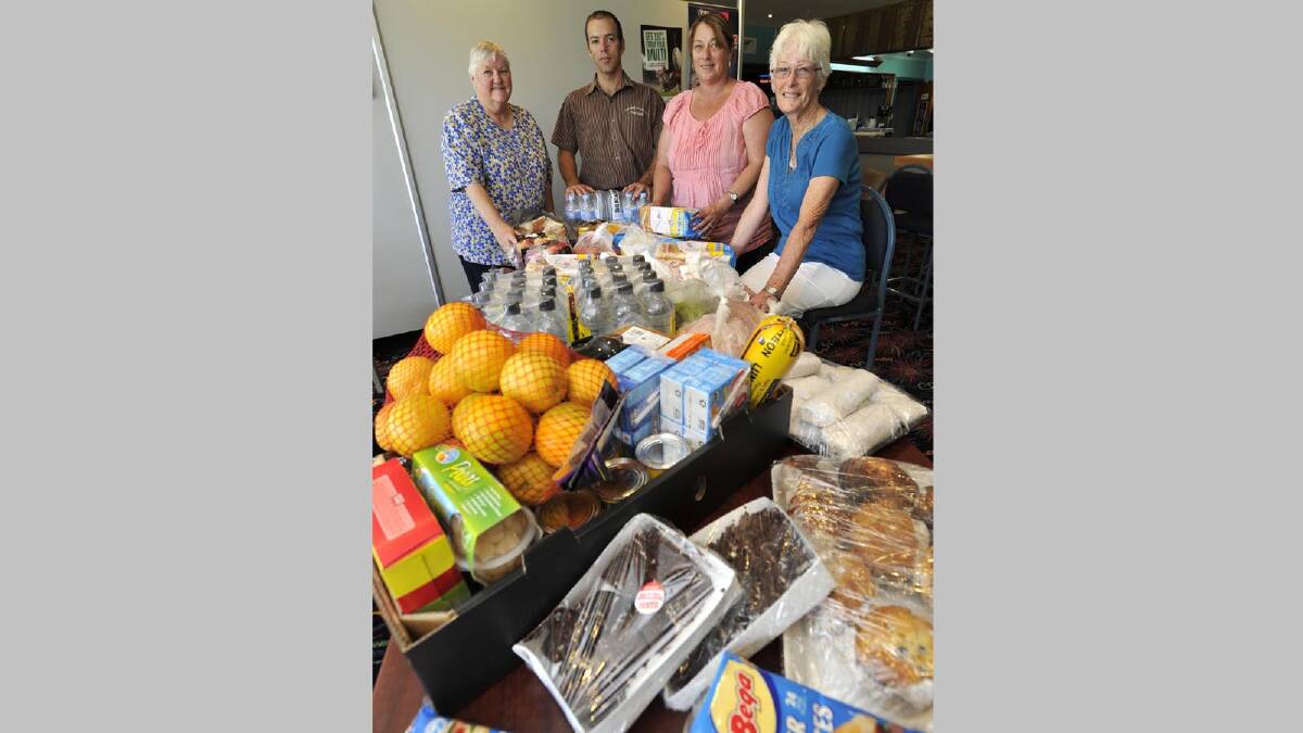 Elizabeth Cribbin, Michael Pratt, Leisa Bradley and Judy Bament with some of the food collected by the Tumbarumba community to help firefighters out yesterday. Picture: Les Smith