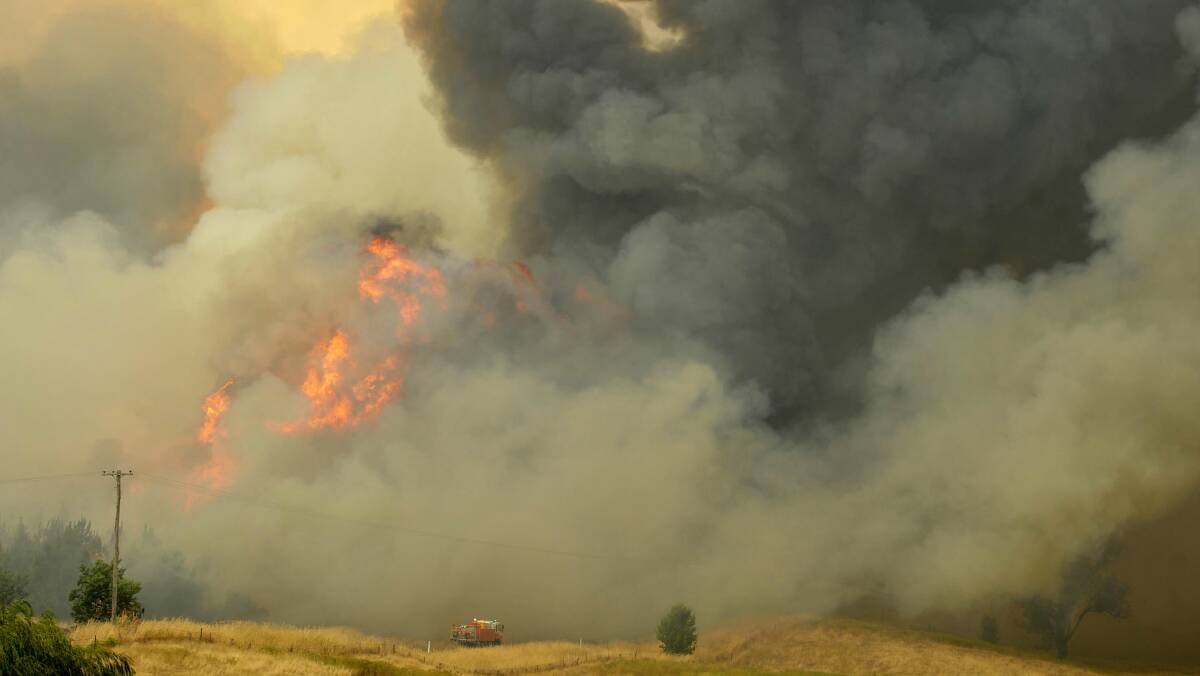 A truck full of Rural Fire Service volunteers heads to the raging fire front at Carabost yesterday. Picture: Les Smith