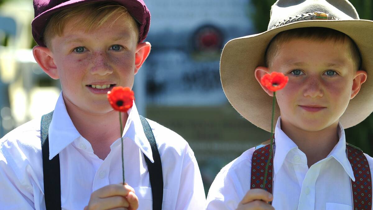Hunter Crozier, 11, and Eli Crozier, 8, picked up two poppies. Each poppy represented one of the original Kangaroo marchers. Picture: Addison Hamilton