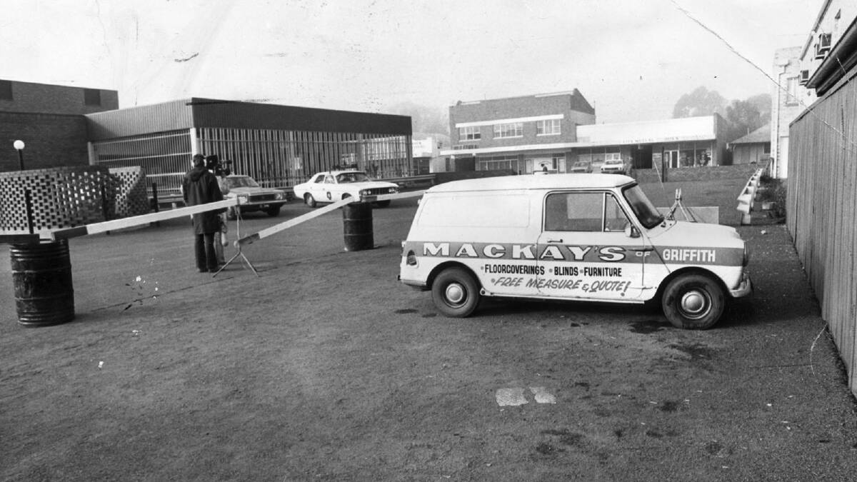 Police create a crime scene around Donald Mackay's mini-van, pictured in the car park of the Griffith Hotel, where he was last seen in 1977.