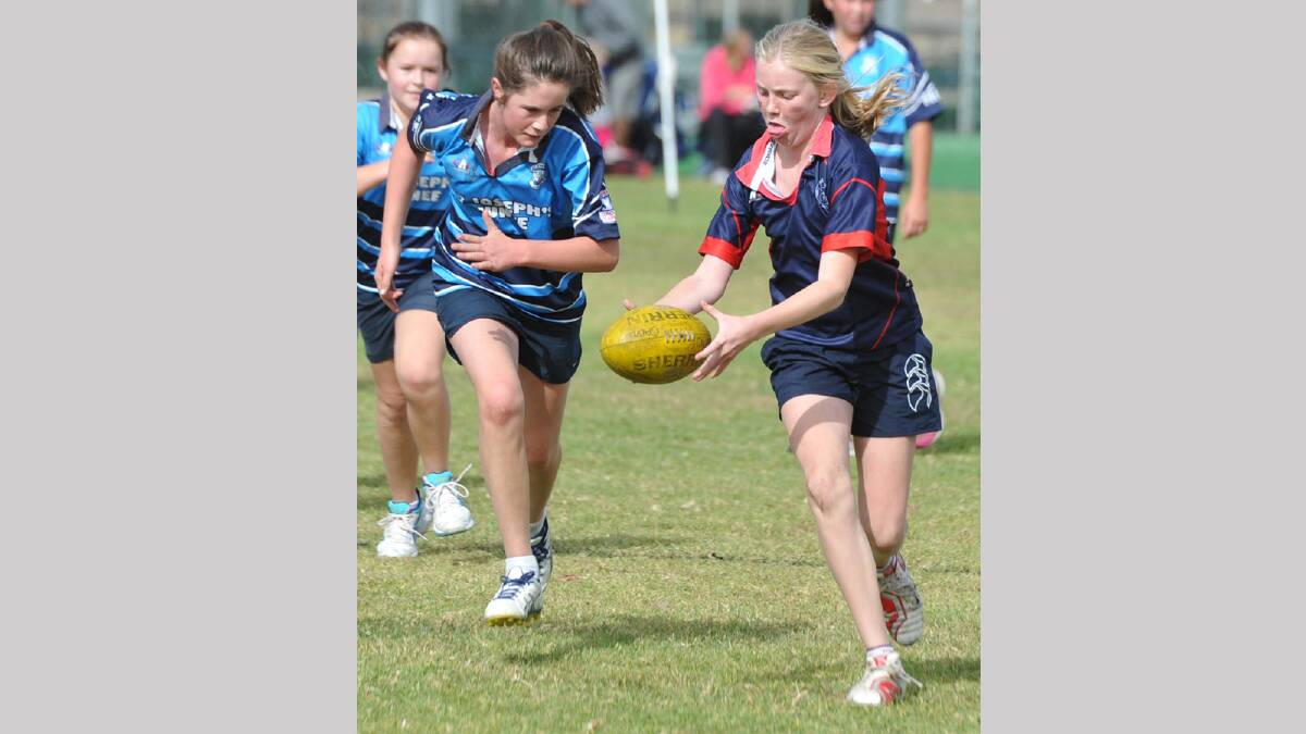 ON THE RUN: Henschke Primary School’s Marnie Broughton looks to get a quick kick away as St Joseph’s Junee’s Frances Heffernan gives chase during one of the girls’ games at the Paul Kelly Cup yesterday. Picture:  Les Smith