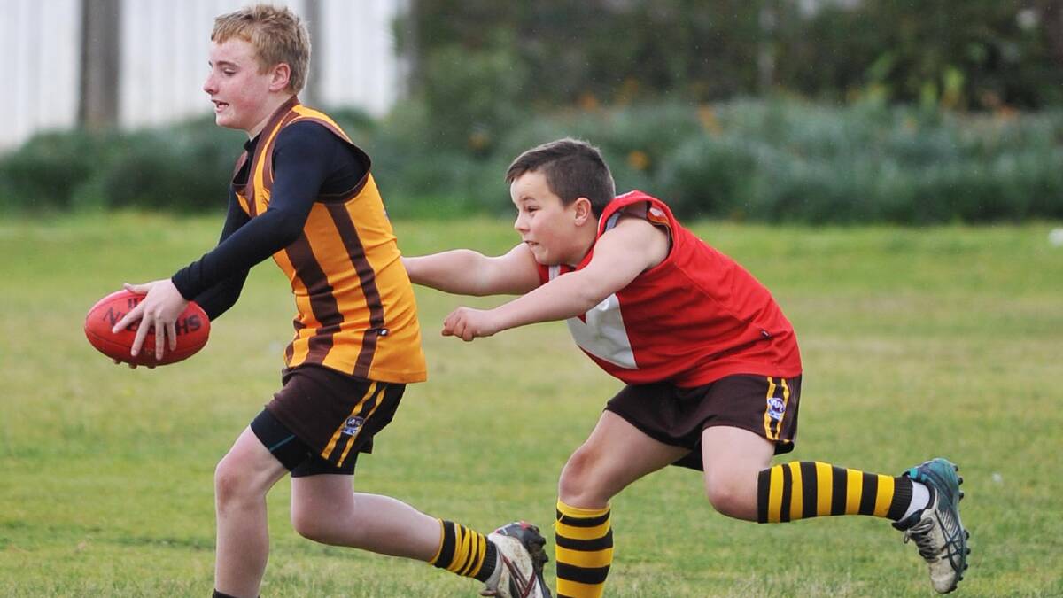 Myles Henman (right) tries to chase down Hayden Nelson in junior Aussie rules. Picture: Alastair Brook