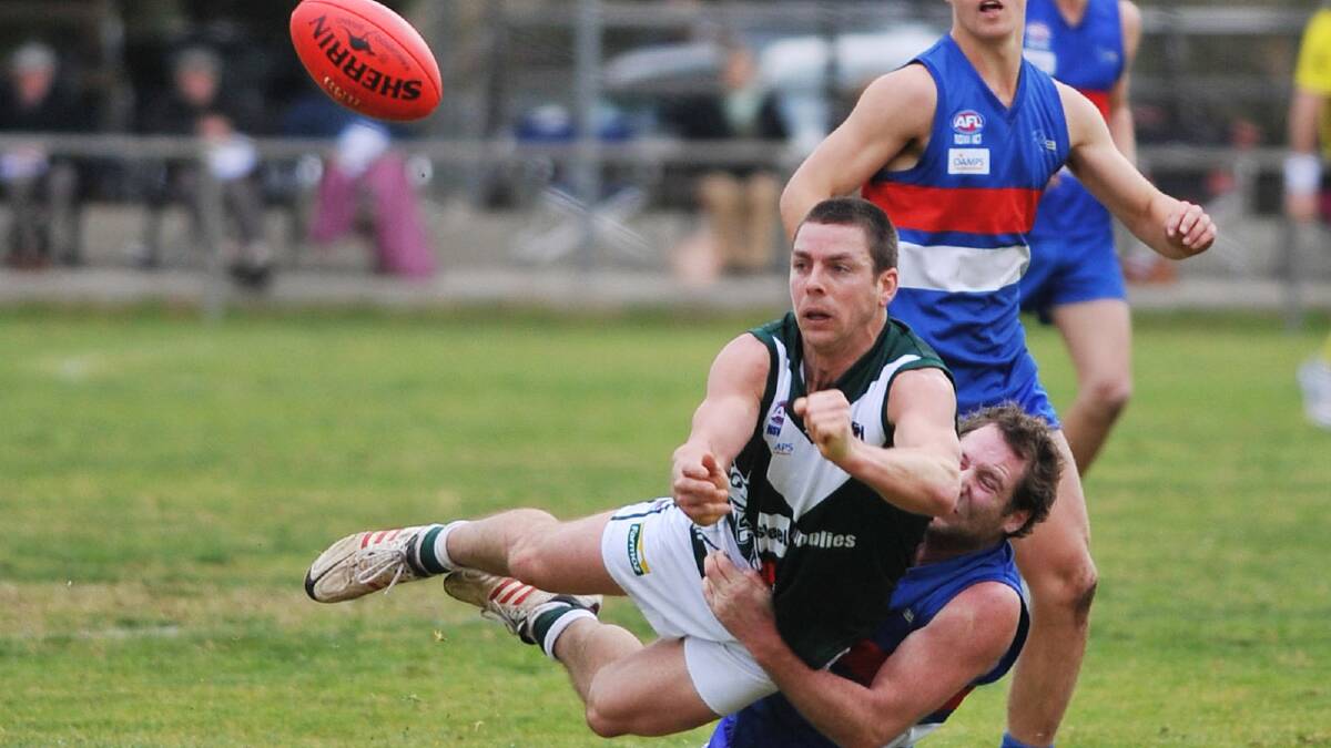 Coolamon's Ryan Chamberlain gets a handball away from being driven to the gound by Turvey Park's Chris Cerato. Picture: Alastair Brook